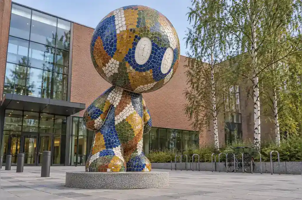 Mosaic cartoon abstract character sculpture on a Helsinki design school forecourt