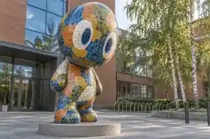 Three-quarter view of a 2.6 m cartoon abstract character covered in hand-cut mosaic tesserae