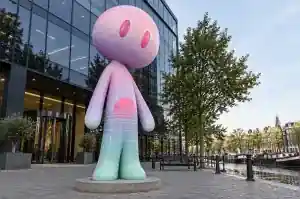 Detail of the neon wireframe grid and half-sun disc on a vapourwave abstract character sculpture