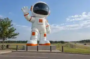 Giant cartoon astronaut landmark sculpture waving over a highway plaza in Oklahoma