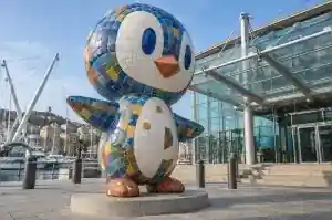 Three-quarter view of a 2.6 m penguin sculpture covered in hand-cut mosaic tiles