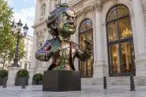 Three-quarter view of a 1.8 m cartoon bust with holographic flip paint shifting green to magenta