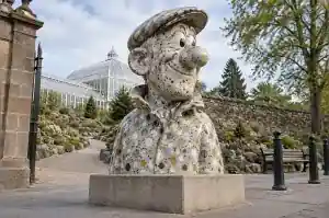 Three-quarter view of a 1.6 m cartoon bust with terrazzo chips in white, black, ochre and sage
