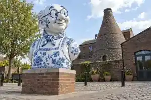 Three-quarter view of a 1.7 m cartoon bust painted with cobalt blue floral scrollwork on white
