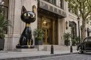 Art deco cartoon cat sculpture in black lacquer with gold accents at a Shanghai hotel entrance