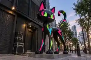 Detail of the fluorescent cyan and pink markings on a UV neon cartoon cat sculpture