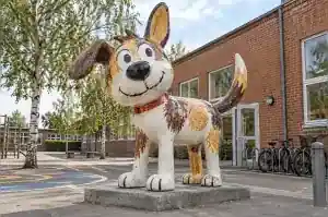 Cartoon dog sculpture finished to look like a child's crayon drawing in a Copenhagen schoolyard
