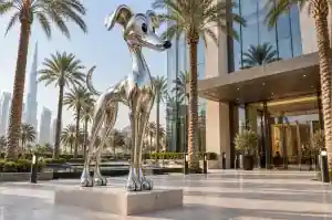 Three-quarter view of a 2.2 m reflective chrome-finish cartoon whippet sculpture
