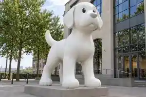 Detail of the rounded head and muzzle of a matte white cartoon labrador sculpture