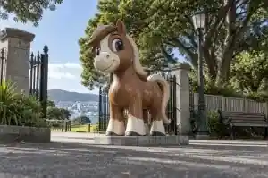 Large cartoon horse sculpture in gloss-painted fibreglass at a public park entrance in Wellington