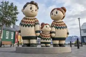 Three-quarter view of a 2.2 m cartoon family sculpture with raised knitted stitch texture