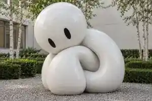 Detail of the oversized head of a chalk-white cartoon abstract character sculpture