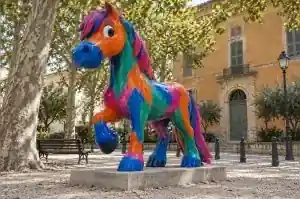 Fauvist painted cartoon horse sculpture in an Arles public garden with bold brush strokes