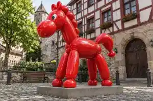 Three-quarter view of a 2.0 m cartoon horse sculpture built from taut twisted balloon volumes