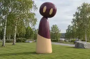 Tall cartoon abstract character sculpture in gloss-painted fibreglass on the lawn of a Norwegian sculpture park