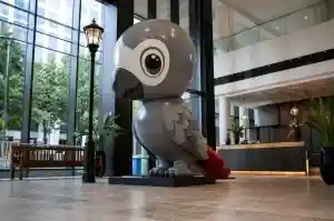 Large cartoon parrot sculpture in gloss-painted fibreglass in a Bristol hotel lobby