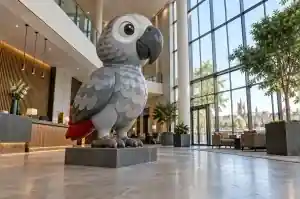 Three-quarter view of a cartoon African grey parrot fibreglass sculpture in a hotel atrium