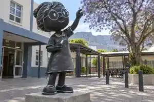 Three-quarter view of a 2.1 m cartoon figure sculpture with white chalk linework on a blackboard ground