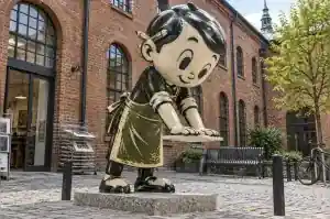 Linocut style cartoon printmaker sculpture in a Krakow arts centre courtyard