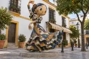 Mosaic cartoon flamenco dancer sculpture in a Seville plaza with hand-cut tesserae