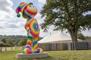 Tie dye cartoon festival goer sculpture on a Somerset festival site