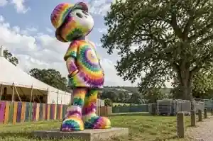 Three-quarter view of a 2.2 m cartoon figure sculpture covered in concentric tie-dye colour rings