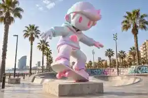 Vaporwave cartoon skateboarder sculpture at a Barcelona skate park with a neon grid pattern