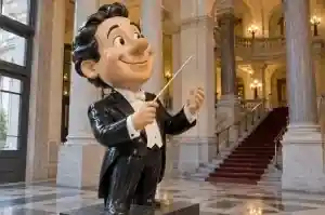 Three-quarter view of a cartoon portrait sculpture holding a conductor's baton, Ghent