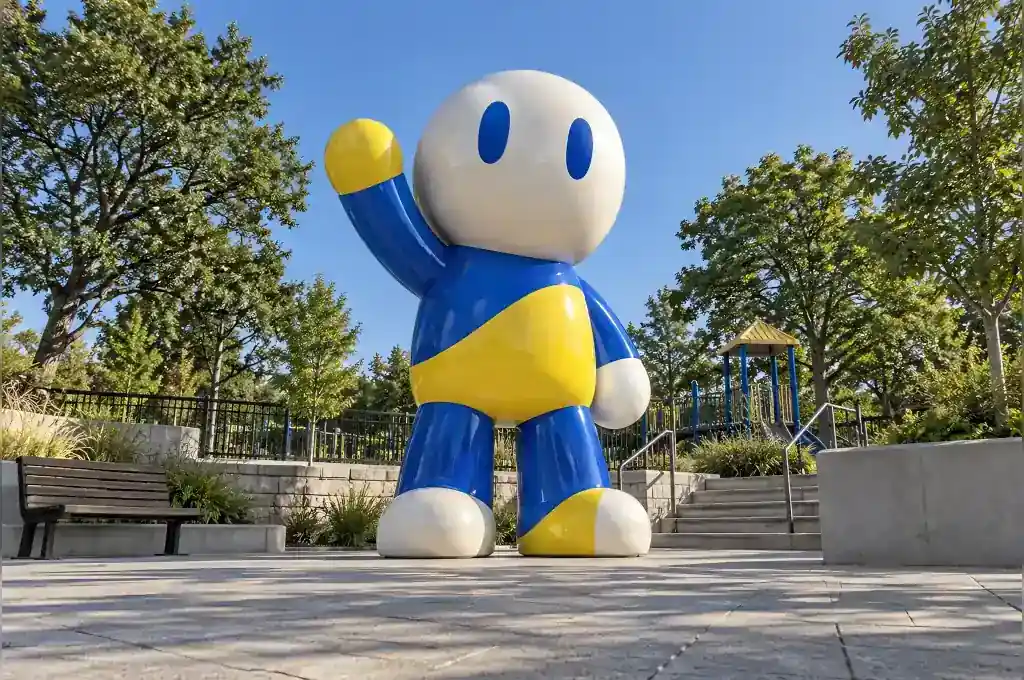 Abstract cartoon character sculpture in gloss-painted fibreglass at a playground entrance plaza in Vienna