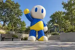 Abstract cartoon character sculpture in gloss-painted fibreglass at a playground entrance plaza in Vienna