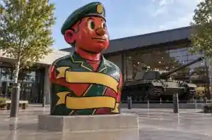 Tattoo-flash painted cartoon veteran bust with heavy black outlines in a regimental museum