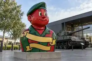 Three-quarter view of a 1.5 m veteran bust sculpture with flat red, gold and green fills
